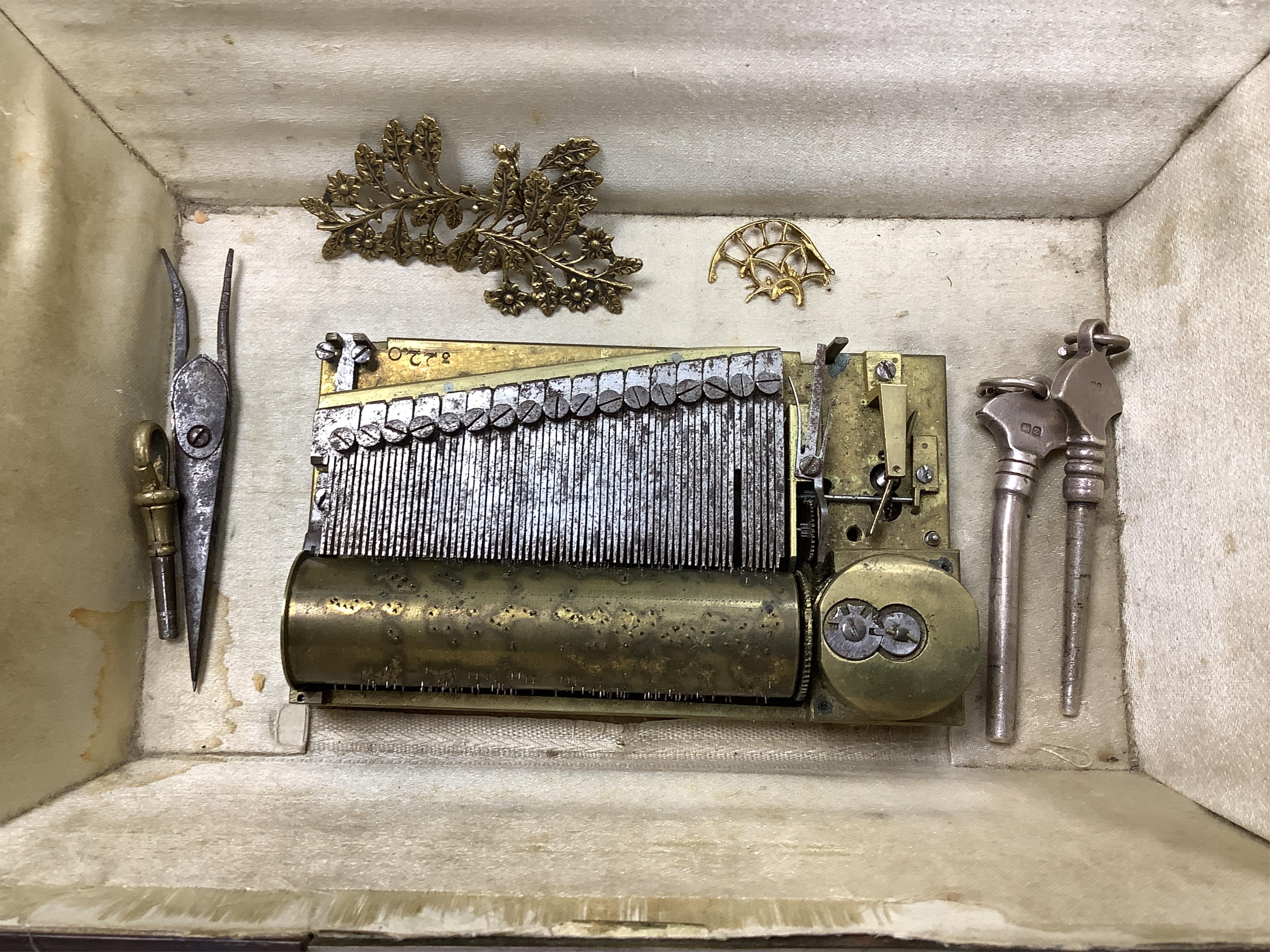 A 19th century burr walnut musical sewing box with mirrored and fitted interior and two silver keys, 18cm wide (mirror cracked)